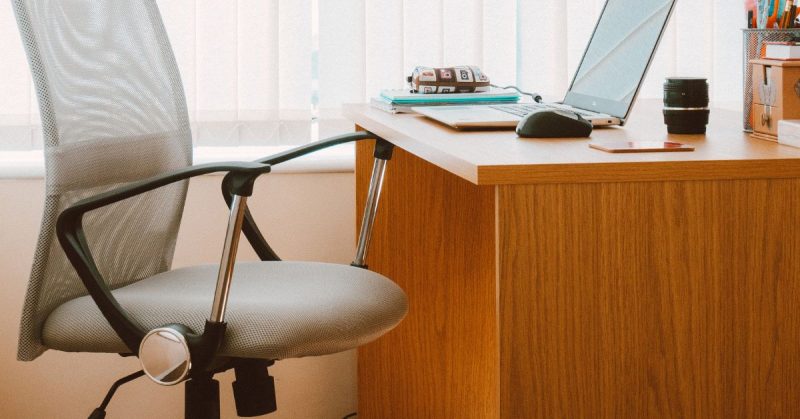 Modern office desk with laptop and chair representing professional support and workplace compassion at Madonna Multinational Funeral Home.