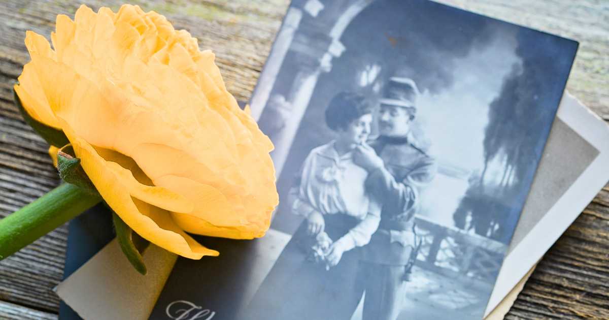 Flower and family photograph representing remembrance during obituary and eulogy planning