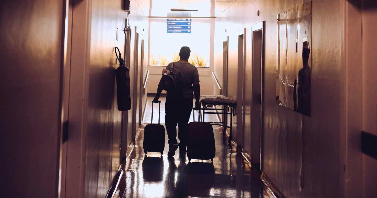 Traveler walking through airport hallway after a death while traveling away from home